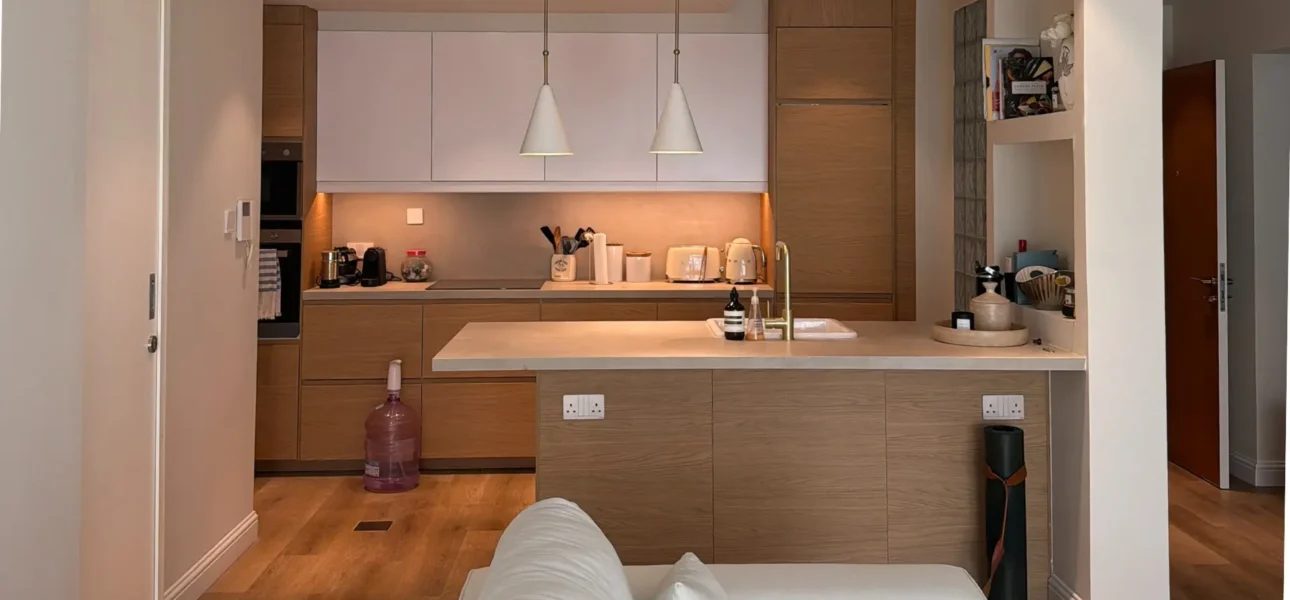 Modern luxury kitchen renovation in The Greens by Nakheel, featuring bespoke oak cabinetry and minimalist design.