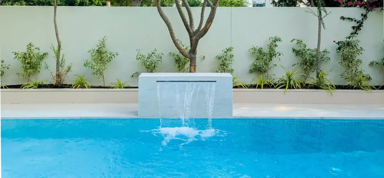 Modern swimming pool with a minimalist stone waterfall feature in Yasmin Villa 3, Arabian Ranches by BBH Builds