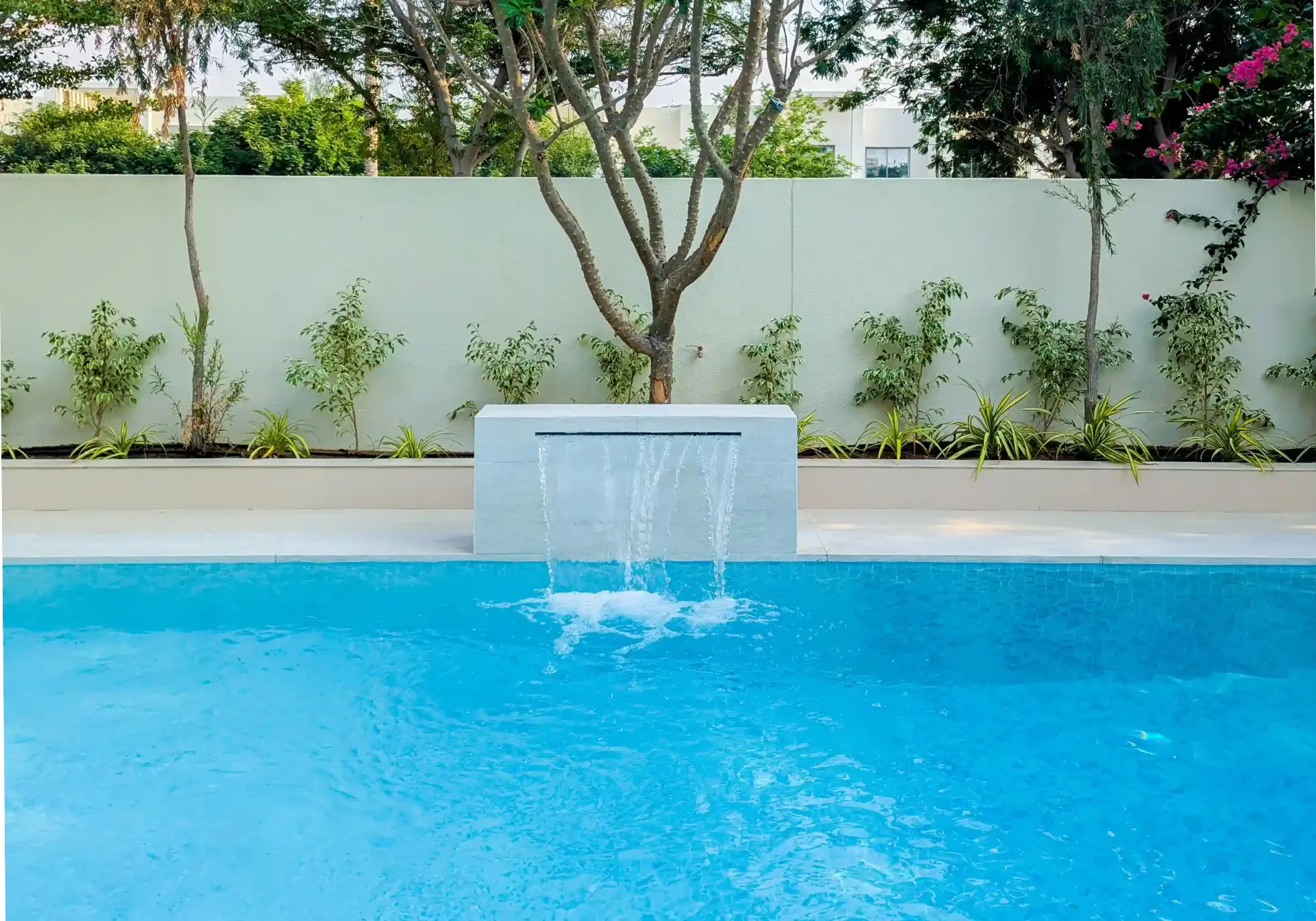 Modern swimming pool with a minimalist stone waterfall feature in Yasmin Villa 3, Arabian Ranches by BBH Builds